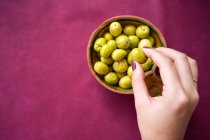 Азійка їсть оливки в ресторані. — стокове фото