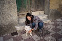 Мирна леді погладжує собаку на вулиці — стокове фото