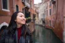 Satisfied Asian resting woman exploring old city with waterways — Stock Photo