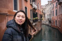 Soddisfatto asiatico riposo donna esplorare vecchio città con corsi d'acqua — Foto stock