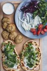 Tavolo da cucina con falafel e verdure fresche sul pane.near con insalata — Foto stock