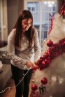 Pregnant woman arranging Christmas tree — Stock Photo