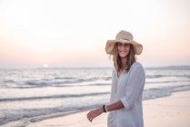 Mulher encantadora em vestido branco claro na praia ondulada — Fotografia de Stock