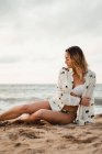 Donna che riposa sulla spiaggia di sabbia il giorno nuvoloso — Foto stock