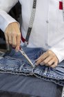 Обрізане зображення працівника на текстильній фабриці, що перевіряє якість одягу. Промислове виробництво — стокове фото
