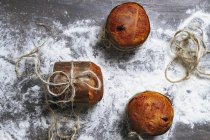 Homemade Italian Christmas panettone cakes on flour on table — Stock Photo