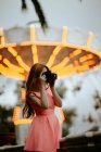 Millennial donna scattare foto con macchina fotografica nel parco divertimenti — Foto stock