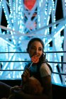 Millennial woman sitting in Ferris wheel and eating lollipop — Stock Photo