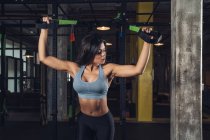 Woman pulling ropes and working out in the gym — Stock Photo