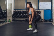 Muscular mujer levantando peso en el gimnasio - foto de stock