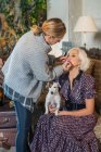 Maskenbildnerin schminkt Model mit gehorsamem Haustier vor Dreh mit Kamera — Stockfoto
