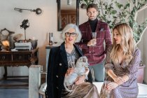 Elegante Seniorin mit erwachsenen Kindern und Haustier gegen Vintage-Interieur zu Hause — Stockfoto