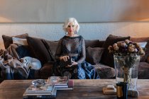 Elégante dame âgée en vêtements de luxe parmi l'intérieur vintage à la maison — Photo de stock