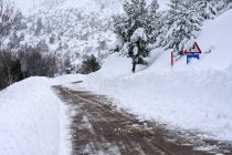Estrada de inverno e sinais com neve no norte da Espanha Montanhas — Fotografia de Stock