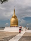 Mujer con paraguas tradicional caminando al lado de la pagoda budista - foto de stock