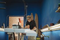 Craftsman cutting out surf board — Stock Photo