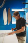 Artesano haciendo tabla de surf en taller - foto de stock