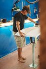 Trabajador con cinta métrica haciendo tabla de surf - foto de stock