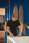 Artesano haciendo tabla de surf en taller - foto de stock