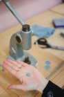From above of tailor demonstrating handmade button over workbench in professional workshop — Stock Photo