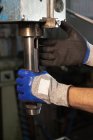 Behandschuhte Hände des Poliers bei der Arbeit an Geräten mit Ventil in der Fabrik — Stockfoto