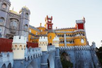 Antiguo castillo con paredes de colores brillantes situado contra el cielo nocturno sin nubes en Portugal - foto de stock