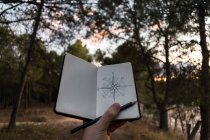 Crop traveler drawing compass on nature — Stock Photo