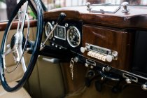 Фрагмент металлического рулевого колеса и приборной панели старого классического автомобиля — стоковое фото