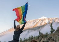 Personne sur le sommet de la montagne agitant le drapeau LGBT — Photo de stock