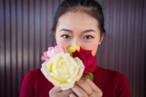 Азиатка, показывающая букет роз на камеру — стоковое фото