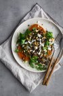 Teller mit leckerem Süßkartoffelsalat und Silberbesteck auf grauem Tisch zum Mittagessen — Stockfoto