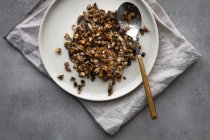 From above plate with boiled buckwheat and spoon placed on napkin during baked sweet potato salad preparation — Stock Photo