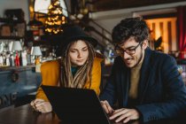 Femme élégante et homme travaillant sur ordinateur portable dans le café — Photo de stock