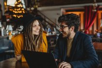 Stylish woman and man working on laptop in cafe — Stock Photo