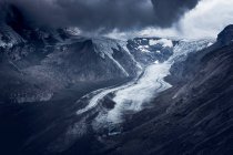 Gray cloudy sky over rough mountain ridge covered with snow on overcast day in Austria — Stock Photo