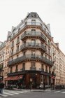 Niedriger Winkel des betagten Gebäudes mit Café in Paris an sonnigen Tagen — Stockfoto