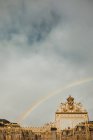 From below of antique gate and rainbow from street of Paris on cloudy day in fall — Stock Photo