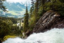 Acqua pulita che cade dalla scogliera di giorno nebbioso in campagna tranquilla in Austria — Foto stock