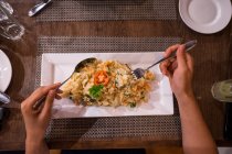 Imagem cortada de mulher comendo prato exótico saboroso no restaurante — Fotografia de Stock