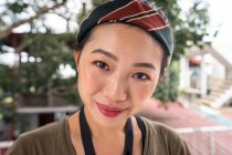 Contenu jeune femme asiatique en vacances avec châle de tête coloré souriant et regardant la caméra à l'hôtel à Sri Lanka — Photo de stock