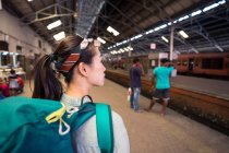 Vista posteriore di giovane donna in vacanza con zaino in attesa di treno alla stazione ferroviaria Colombo in Sri Lanka — Foto stock