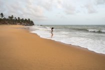 Mujer pacífica en la playa solitaria - foto de stock