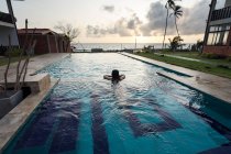 Viaggiatore femminile in costume da bagno a riposo in piscina presso il resort — Foto stock
