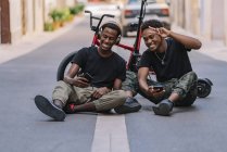 Веселий молодий афроамериканець - підліток, який робить фотографії на мобільному телефоні з радісним чорним хлопцем у навушниках. — стокове фото