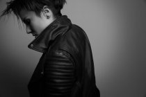 Forte jovem roqueiro feminino em jaqueta de couro no estúdio — Fotografia de Stock