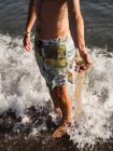 Uomo del raccolto con immondizia di plastica in mare — Foto stock