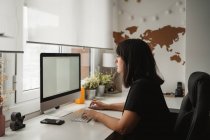 Donna d'affari focalizzata che utilizza il computer desktop in ufficio — Foto stock