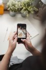 Невпізнавана жінка-художник робить фотографії на смартфоні на роботі — стокове фото