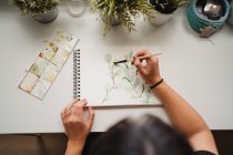 Безликая художница рисует акварелью дома — стоковое фото