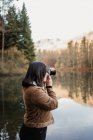 Женщина фотографирует на берегу озера — стоковое фото